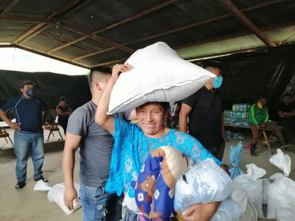 woman smiles after receiving aid after tropical storm eta