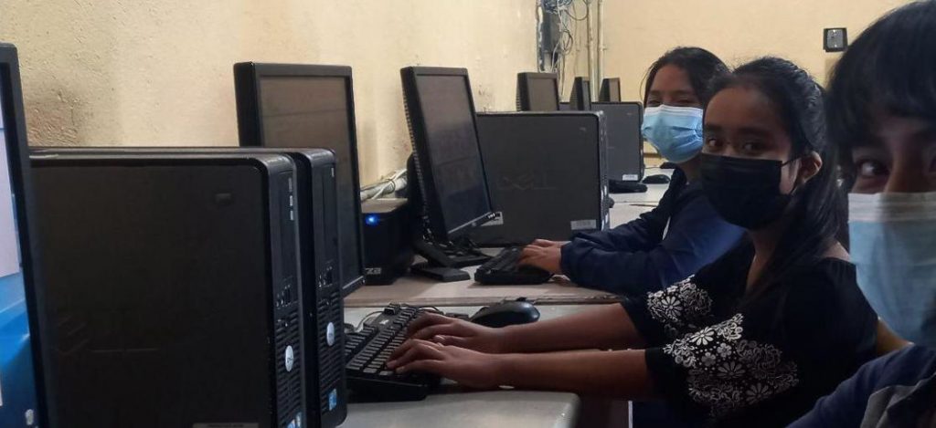 Three female Guatemalan students working in a computer lab